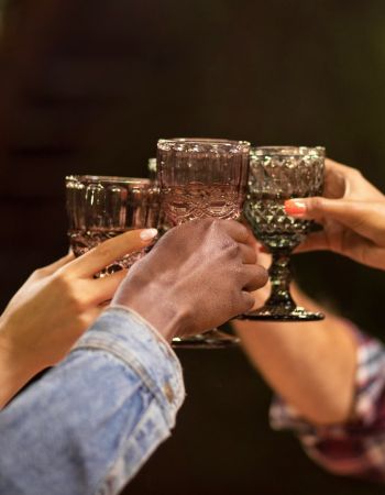 Valley Creek Four people clinking ornate glasses outdoors, symbolizing celebration or a toast.
