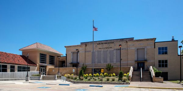Valley Creek Exterior of a high school building with an American flag on a sunny day.